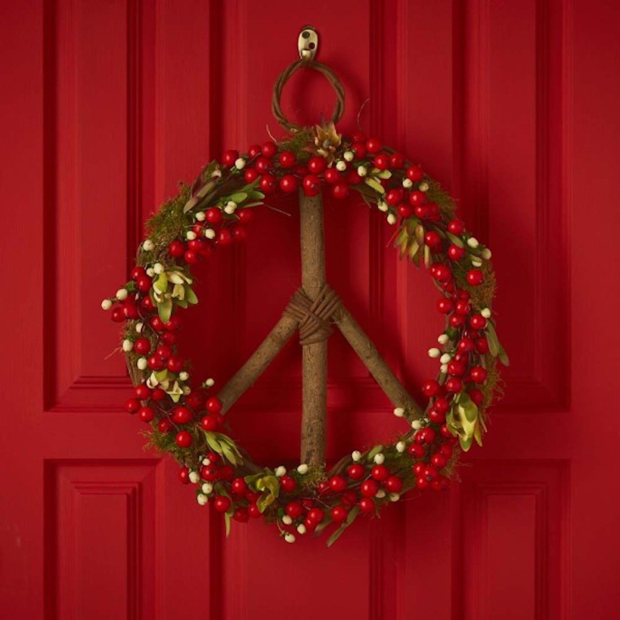 Wreath designed with christmas colors displayed against a red door - home decor collection at Better World Bio