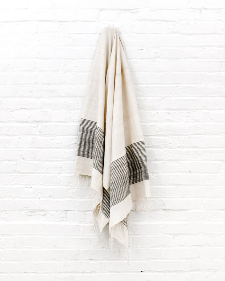 Gray and white bath towel folded neatly, showcasing soft texture and minimalist design for a modern bathroom.