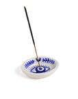 A hand painted blue and white ceramic incense holder holding an incense stick