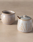 Ceramic cream and sugar bowl set with geometric patterns on a beige background