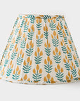 Lamp shade with yellow and green leaf pattern on a white background
