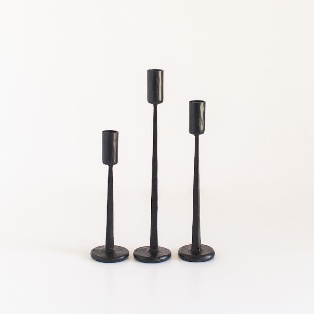 A set of three black finish iron candlesticks in varying heights, displayed against a white background.