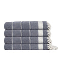 Stack of three folded blue and white patterned towels on a white background
