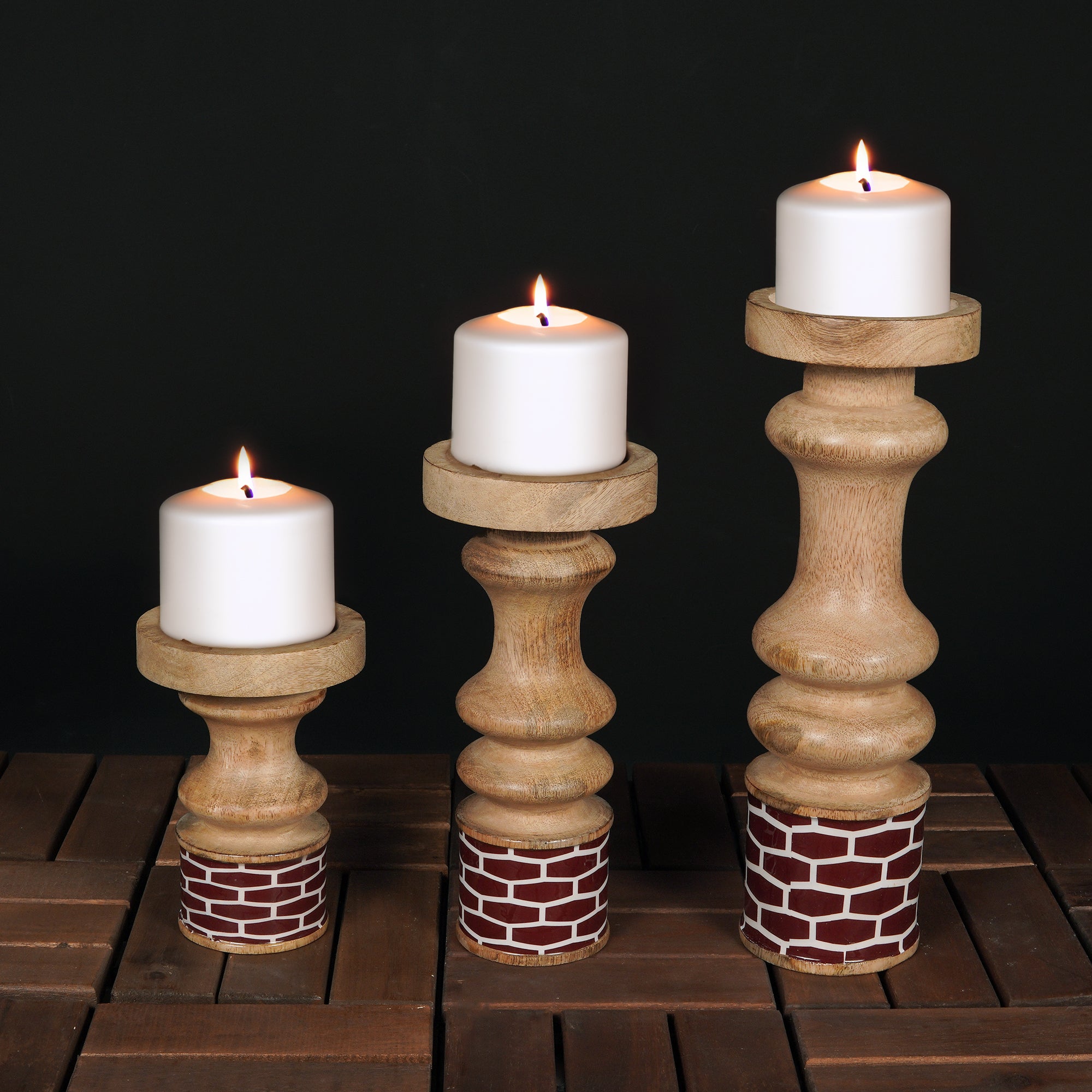 Three wooden candle holders with candles on a dark background
