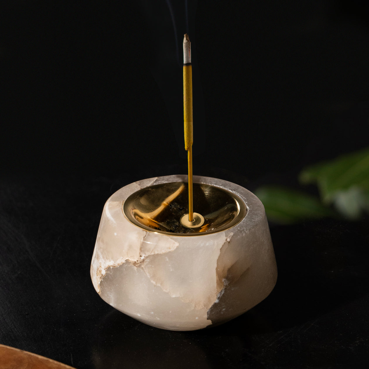 Incense burner with a single incense stick on a dark background