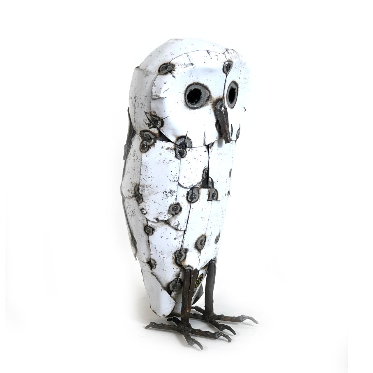White owl statue with black speckles on a white background