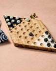 Wooden chinese checkers game board with marbles on a beige background