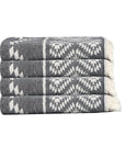 Stack of gray and white patterned towels on a white background