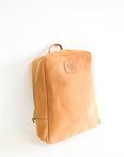 A leather book bag in tan, displayed upright against a white background.