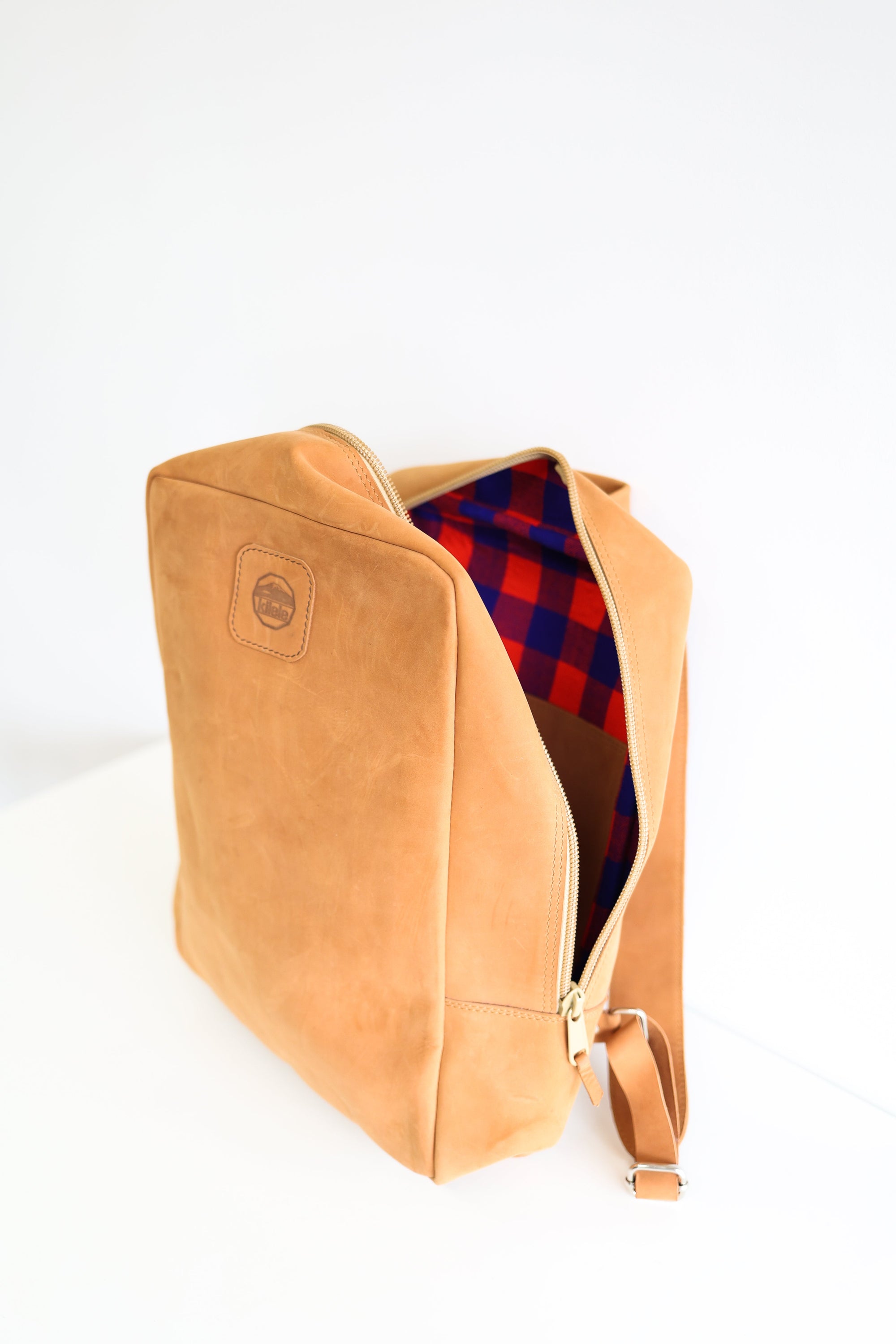 An open leather book bag in tan, displayed upright against a white background.
