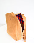 An open leather book bag in tan, displayed upright against a white background.