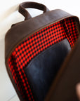 An unzipped inside view of a leather book bag in brown, displayed upright against a white background.