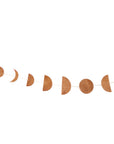 A garland featuring various phases of the moon made from brown leather, strung on a thread