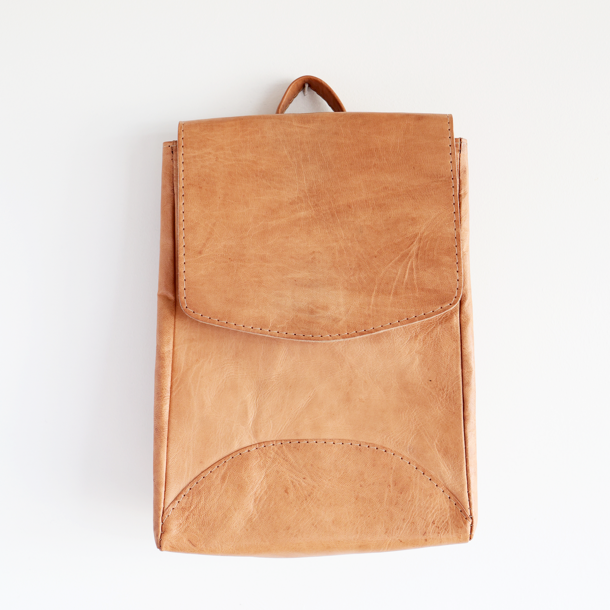Brown leather backpack on a white background