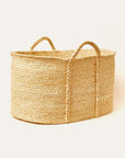 A rectangular braided raffia floor basket with handles, displayed against a neutral background
