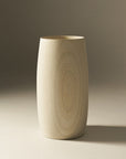 A beige, cylindrical wooden vase with a smooth finish, displayed against a neutral background.
