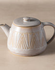 Ceramic teapot with geometric design on a beige background