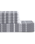 Stack of gray towels with white stripes and fringes on a white background