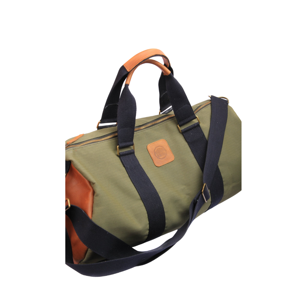 A green and brown duffel bag with black straps and a tan leather bottom, standing upright on a plain background.