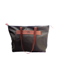 A green canvas tote bag with brown leather accents and dark brown straps, standing upright against a solid background.