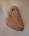 A hand-carved wooden cutting board with a smooth finish and a hole on one corner for hanging