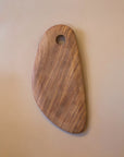 A medium-sized, hand-carved wooden cutting board with a smooth finish and a hole for hanging