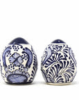 Two handmade ceramic spice shakers with blue floral patterns on a white background, one larger with five holes on the top, and a smaller one with a single hole