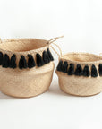 Two woven baskets with black tassels on a white background