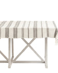 Aden striped cotton tablecloth laid on a rectangular table with a white frame, showcasing the striped pattern