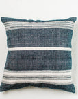 A striped blue and white cotton throw pillow with a hand-woven texture and a zipper closure