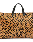 A leopard print hair-calf leather weekender bag with a roomy design and a black handle.