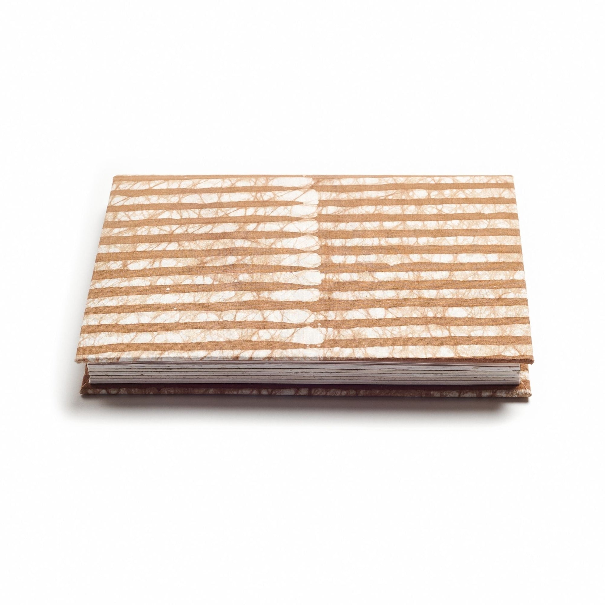 Notebook with a beige and white striped cover on a white background