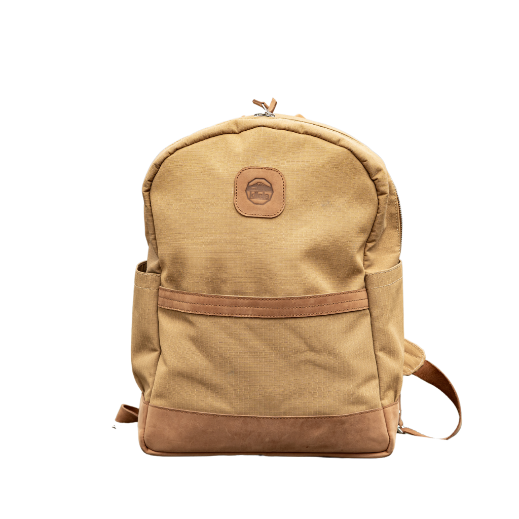 A beige and brown Cape Buffalo book bag with a large main compartment and a laptop sleeve, made from ripstop canvas with leather accents.