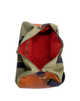 The inside of a green and brown duffel bag with black straps and a tan leather bottom, standing upright on a plain background.