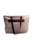 A beige canvas tote bag with brown leather accents and dark brown straps, standing upright against a solid background.