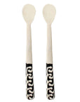 A pair of 8-inch long white bone appetizer spoons with black and white batik patterns on the handles
