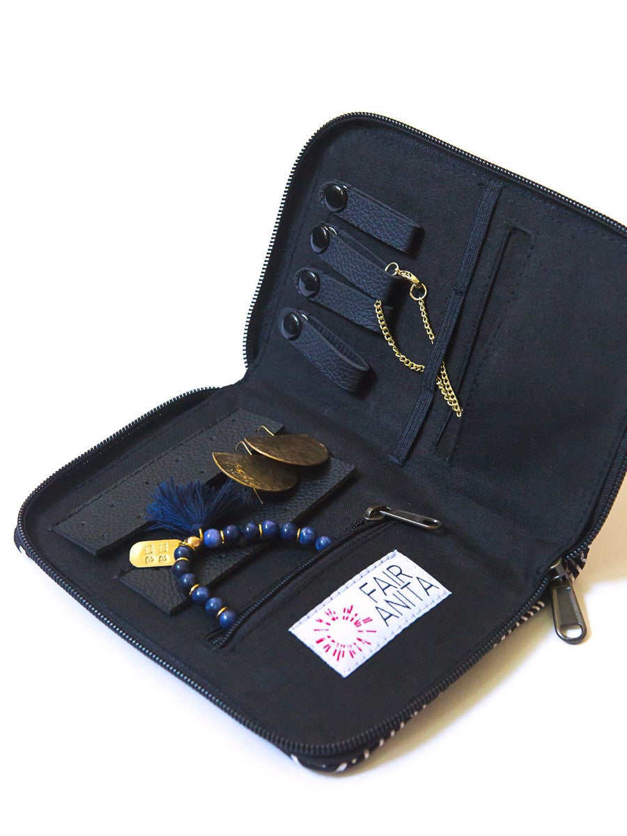 An open navy blue zippered jewelry travel organizer with a geometric pattern, featuring compartments for organizing jewelry such as earrings, rings, and necklaces.