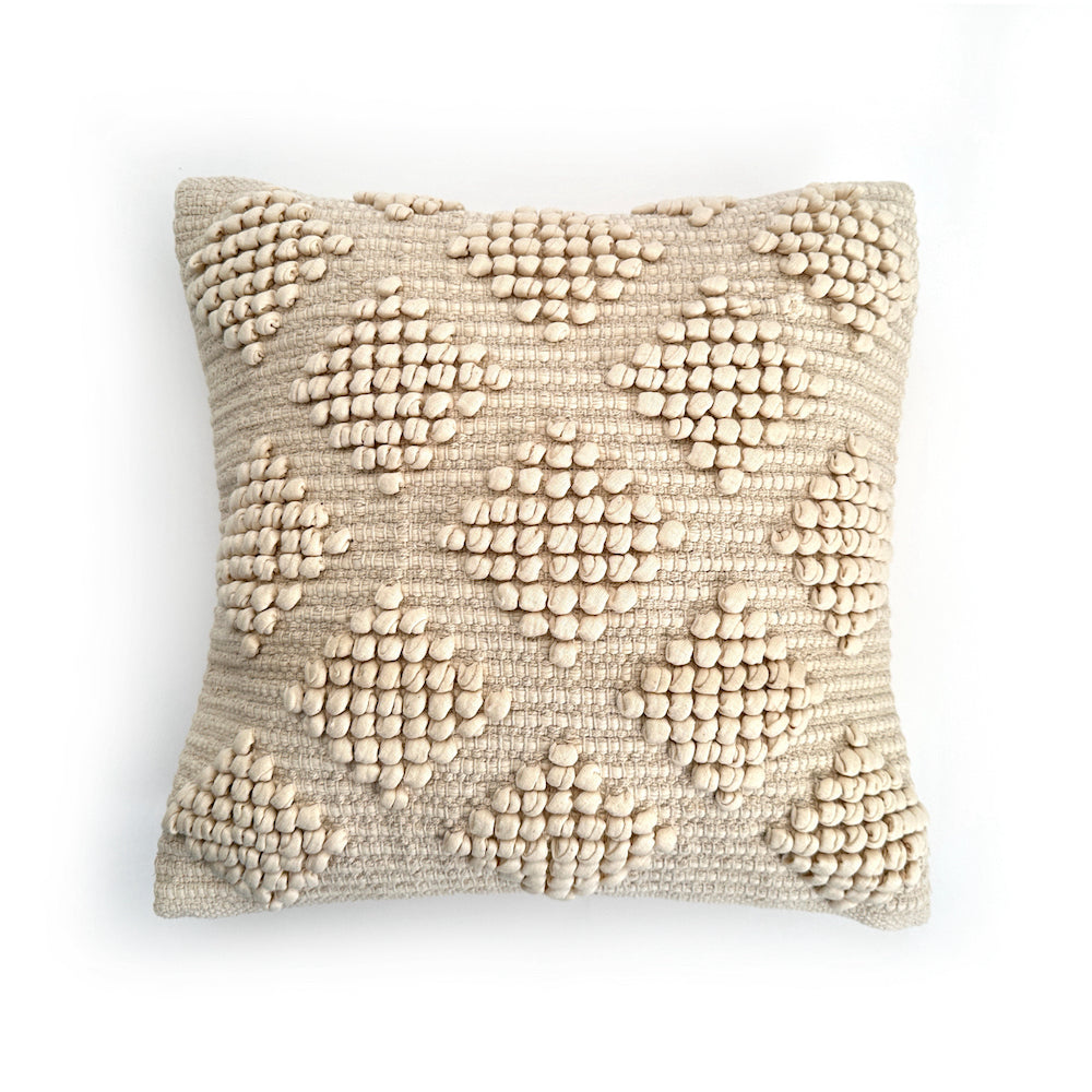 Textured beige pillow on a white background