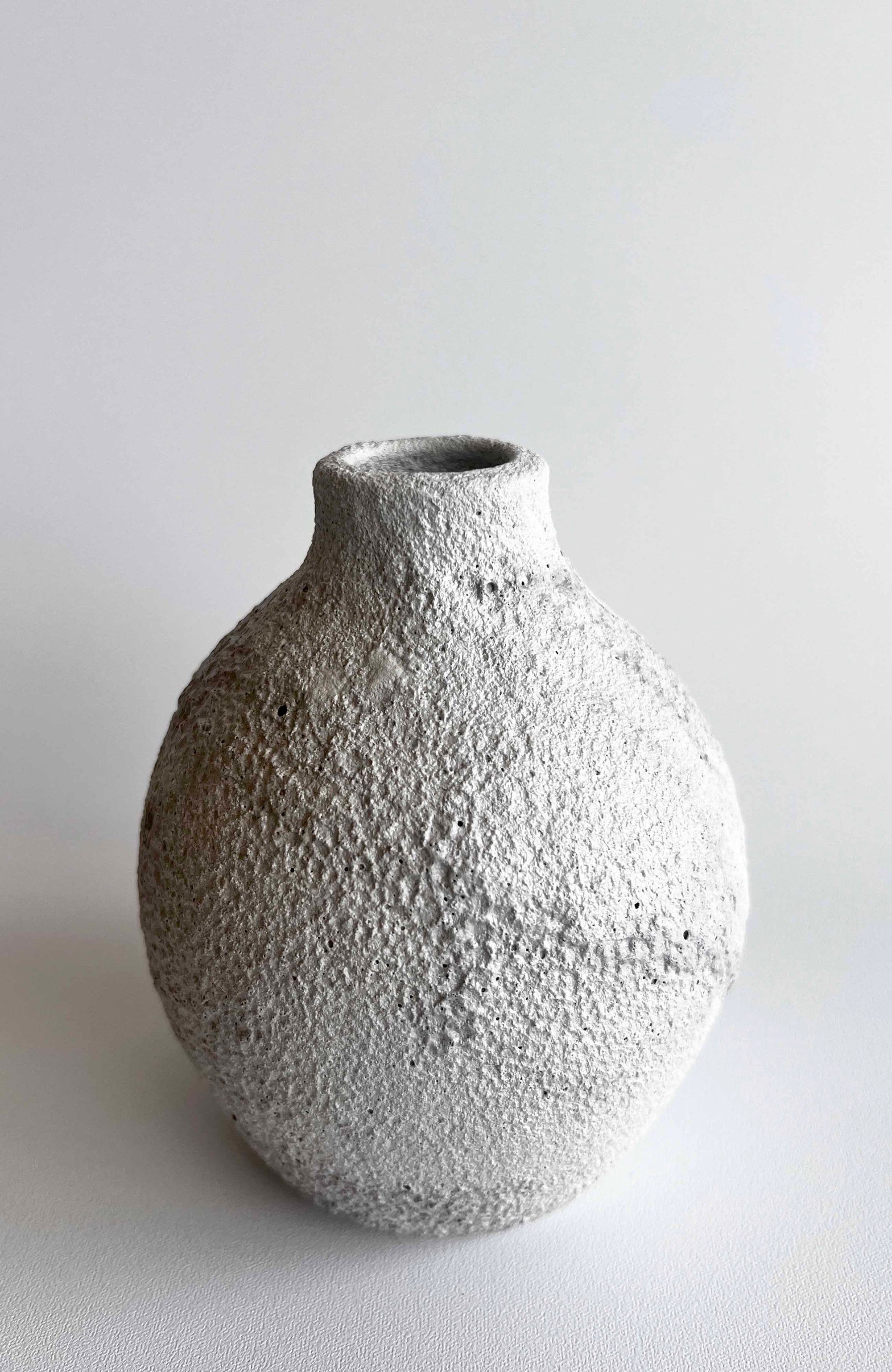 Textured gray ceramic vase on a light gray background