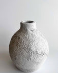 Textured gray ceramic vase on a light gray background