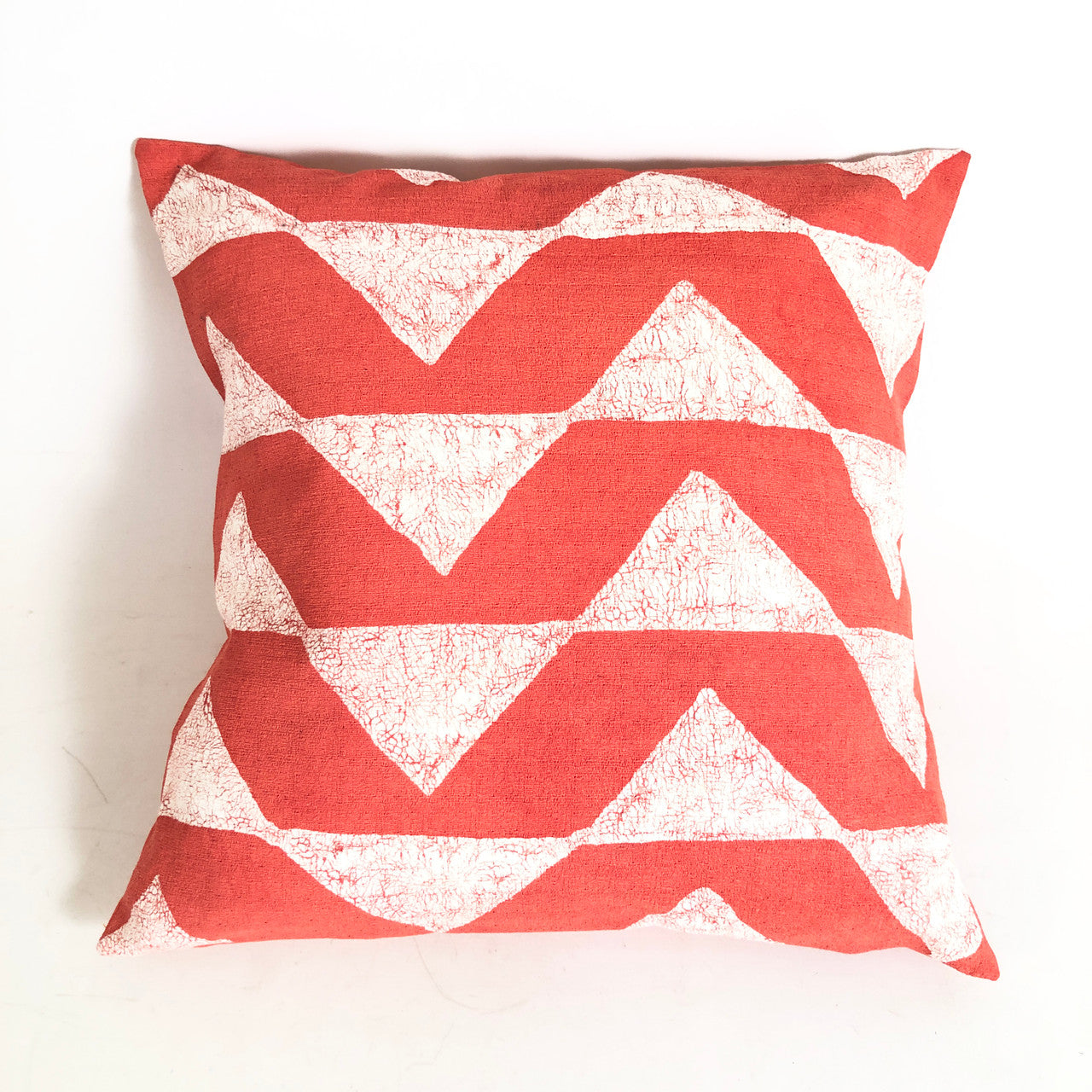 Red and white chevron patterned pillow on a white background