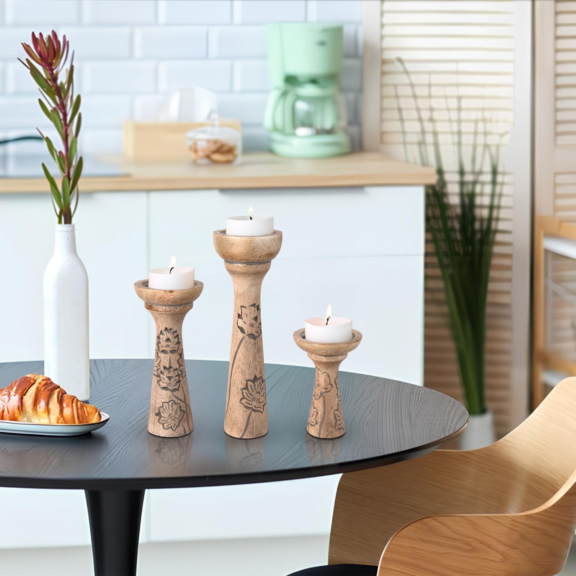 Decorative wooden candle holders with candles on a table in a kitchen setting.
