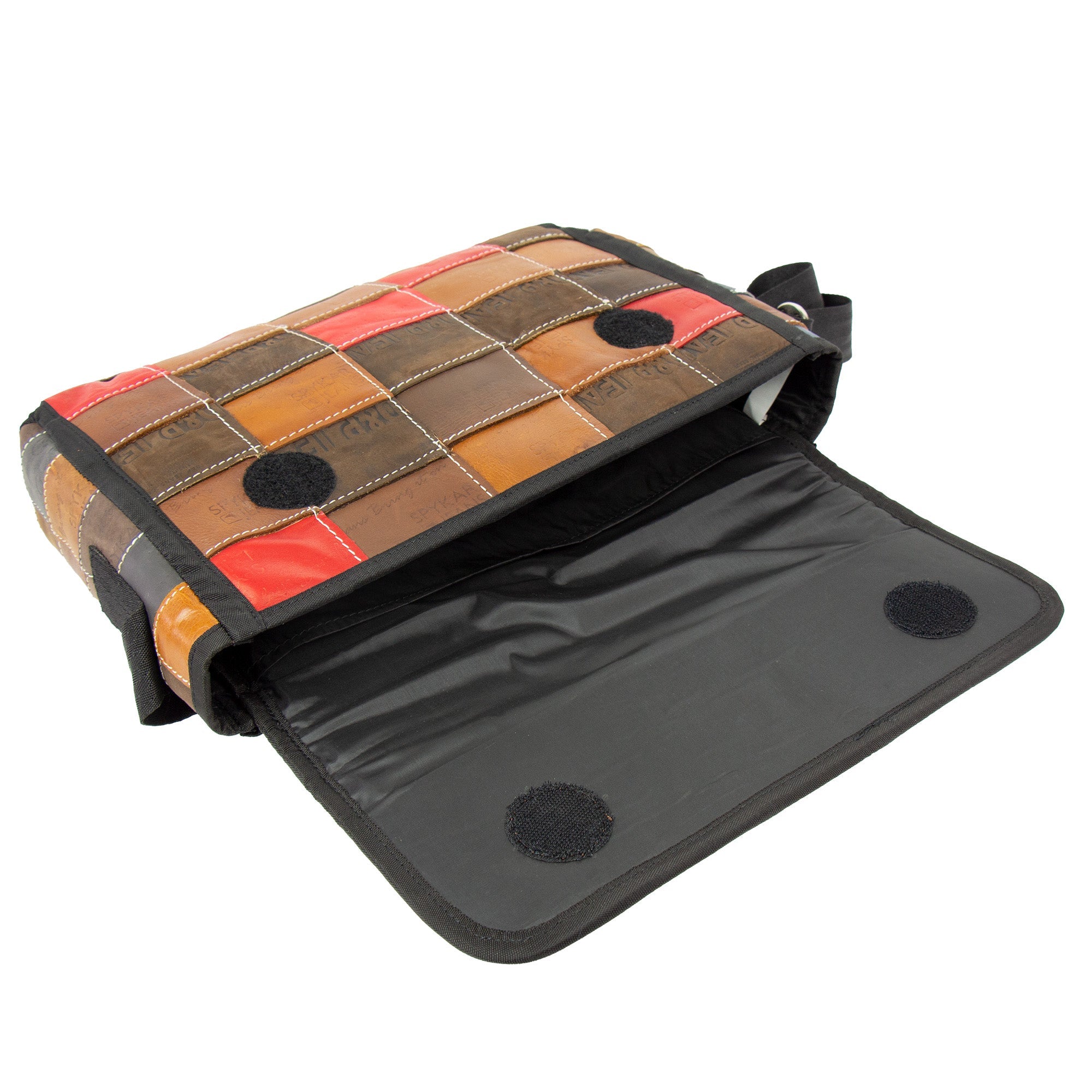 A crossbody bag with a patchwork design made from upcycled leather, featuring a black nylon strap and interior pockets, in brown, red, and blue colors with the flap closure open.