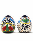 A pair of handmade ceramic spice shakers, featuring a colorful dots and flowers pattern