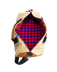 The inside of a beige and brown duffel bag with black straps and a tan leather bottom, standing upright on a plain background.