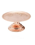 A vintage inspired copper cake stand with a raised edge and pedestal base
