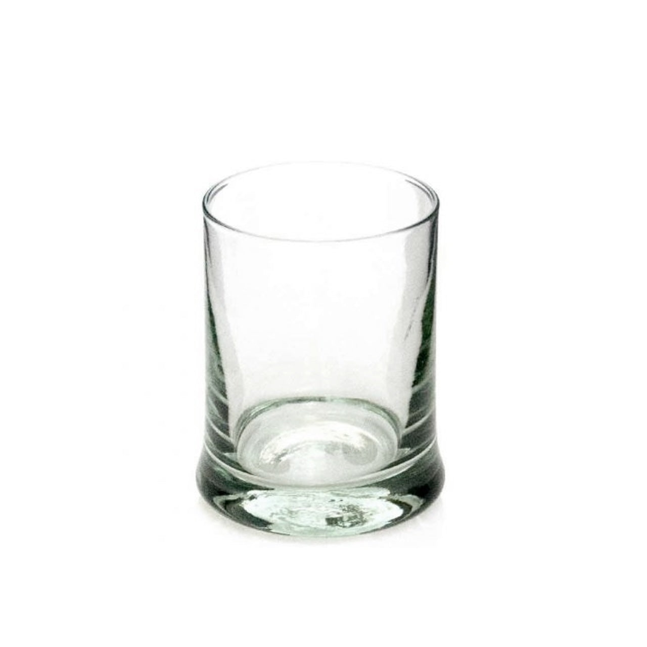 A clear handblown whiskey tumbler with a thick bottom and no visible contents