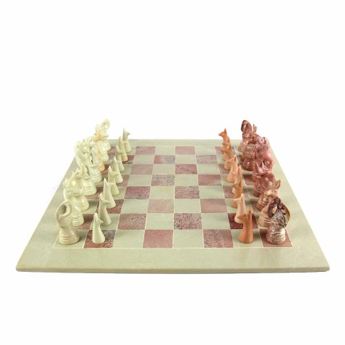 A hand-carved soapstone chess set with a green and pink checkered board and beige, pink, and white stone pieces.
