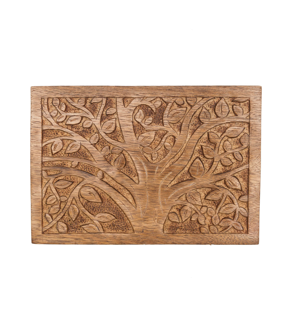 Wooden cutting board with intricate carvings on a white background