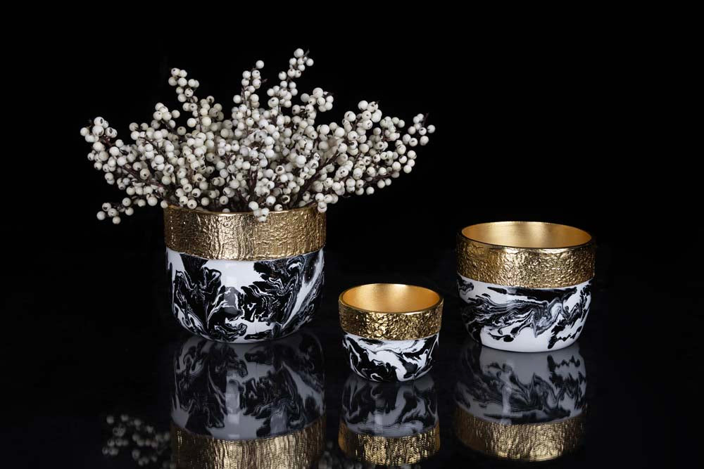 Decorative vases with gold accents and marble patterns on a black background